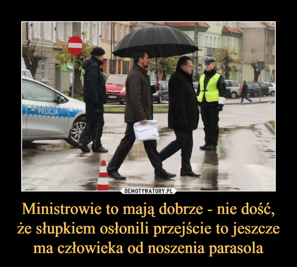 Ministrowie to mają dobrze - nie dość, że słupkiem osłonili przejście to jeszcze ma człowieka od noszenia parasola –  